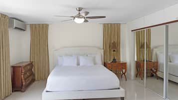 Un dormitorio con cama, ventilador de techo, cómoda y espejo.