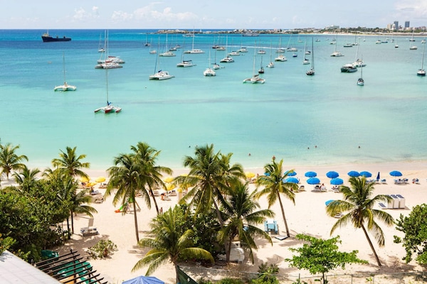 On the beach, white sand, sun-loungers, beach umbrellas
