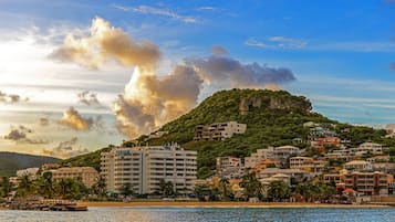 A coastal town with a prominent hill, buildings, and a beach.