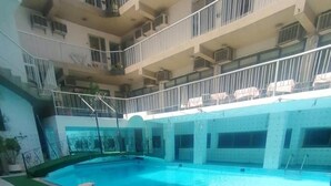 A large indoor swimming pool with a tiled deck surrounding it.