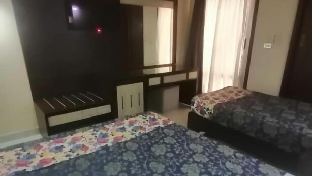 Een hotelkamer met een bed, een bureau en een kledingkast.