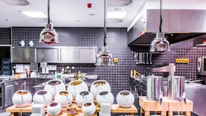 Una cocina moderna con varias estaciones de servicio, incluyendo fuentes de comida y utensilios.