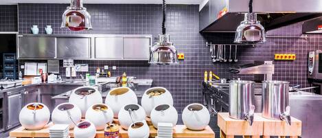 Una cocina moderna con varias estaciones de servicio, incluyendo fuentes de comida y utensilios.
