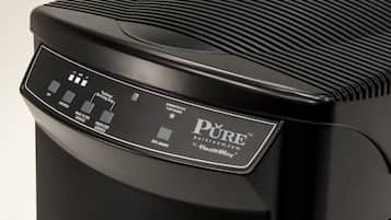 A black air purifier with a control panel displaying various settings.