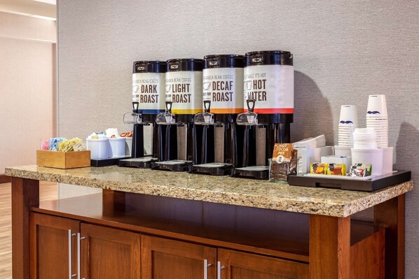Una estación de café con dispensadores etiquetados como 'Dark Roast', 'Light Roast', 'Decaf Roast' y 'Agua Caliente'.