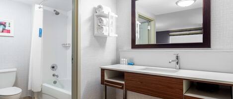Une salle de bain moderne équipée d’une douche, de toilettes et d’un meuble-lavabo avec un miroir.