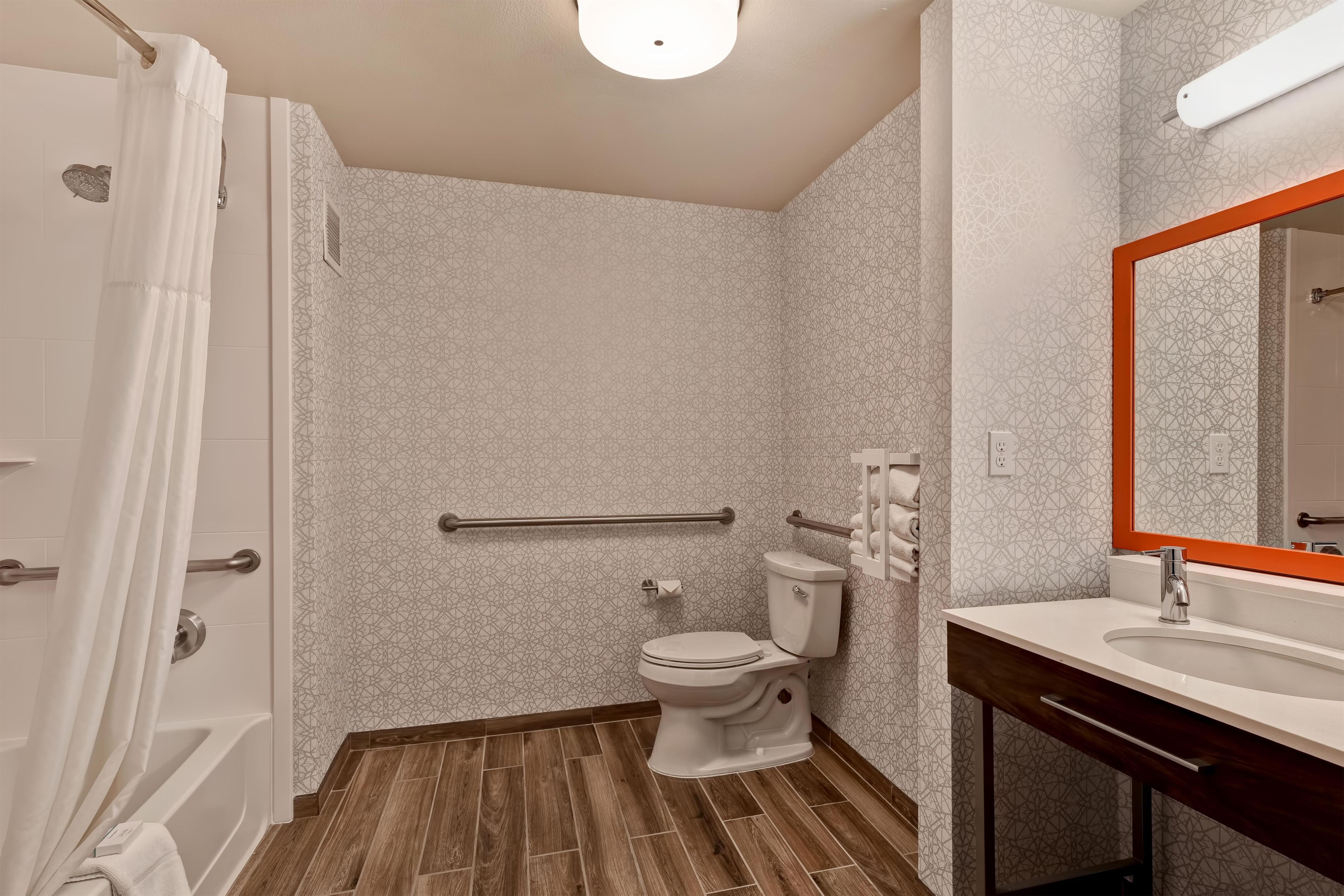 Une salle de bain avec douche, toilettes et lavabo.