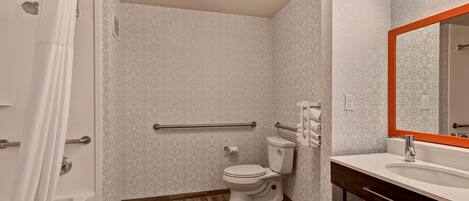 Une salle de bain avec douche, toilettes et lavabo.