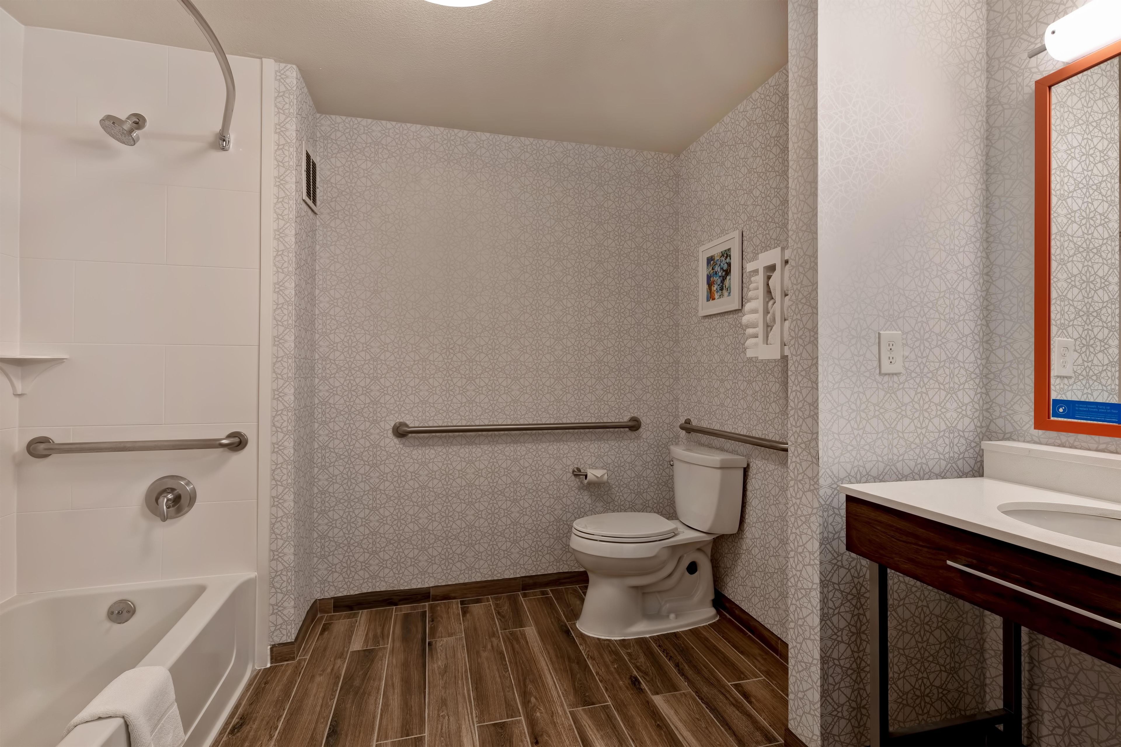 A bathroom with a shower, toilet, and sink.