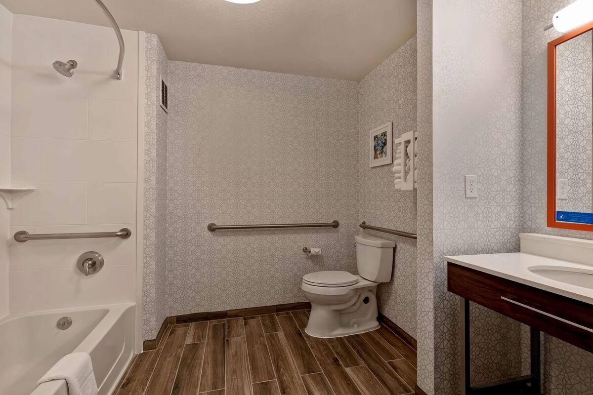 A bathroom with a shower, toilet, and vanity.
