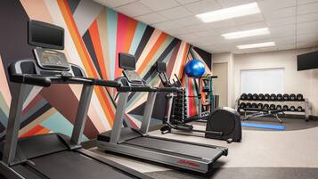 A gym with treadmills, a stationary bike, and a weight bench.