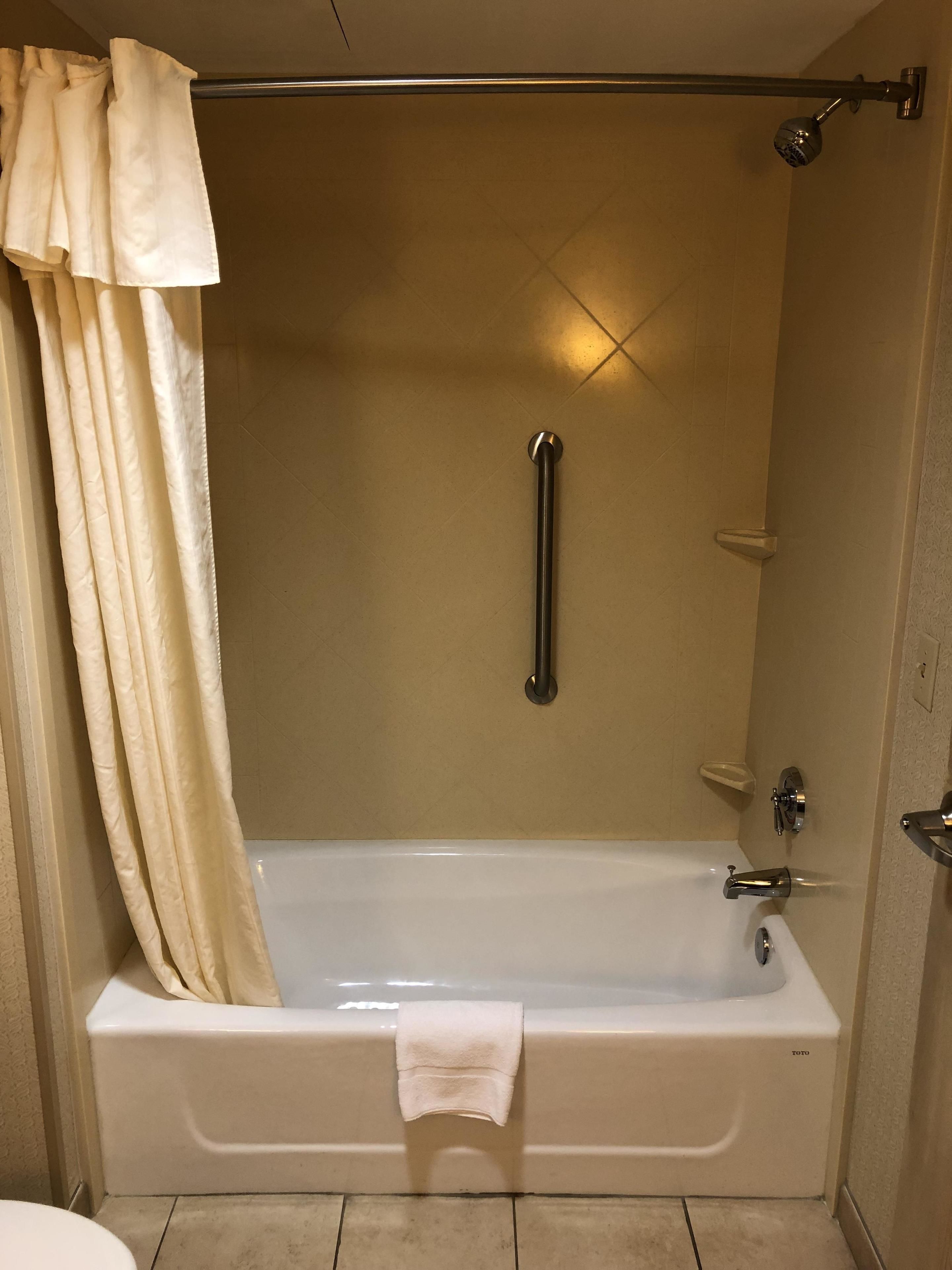 A bathroom with a bathtub, a shower area, and a toilet.