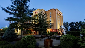 A hotel with a central courtyard, a large tree, and a statue.