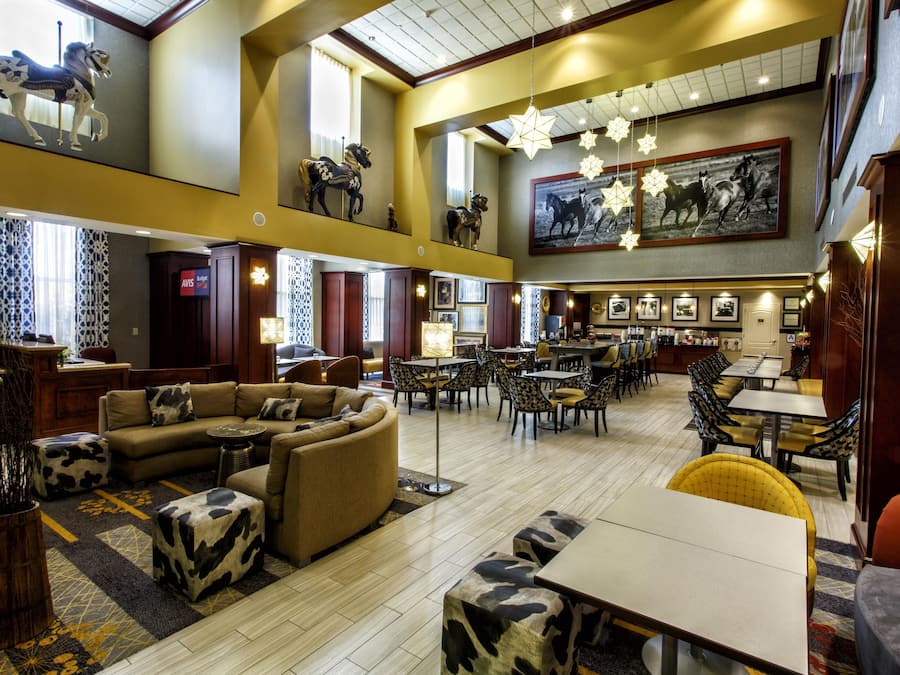 A spacious lobby with a high ceiling, multiple seating areas, and a large dining section.