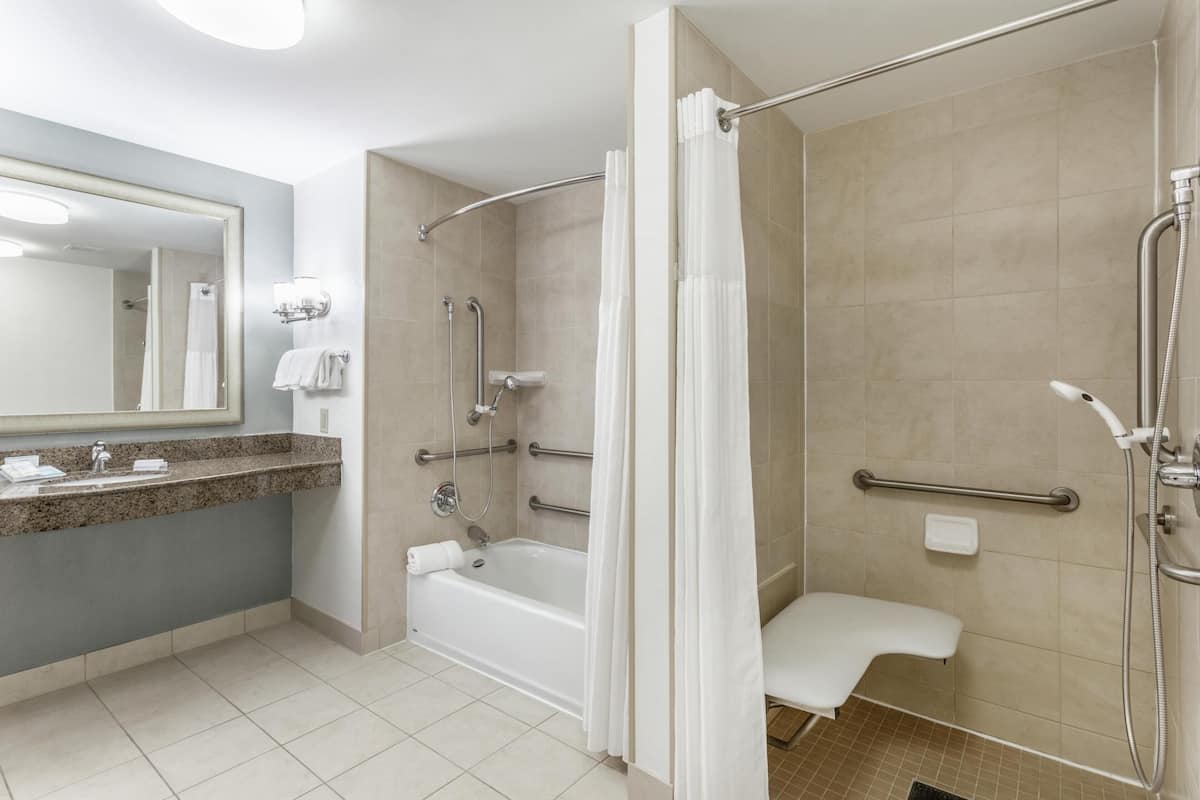 Ein modernes Badezimmer mit Badewanne, Dusche und Waschtisch mit Spiegel.