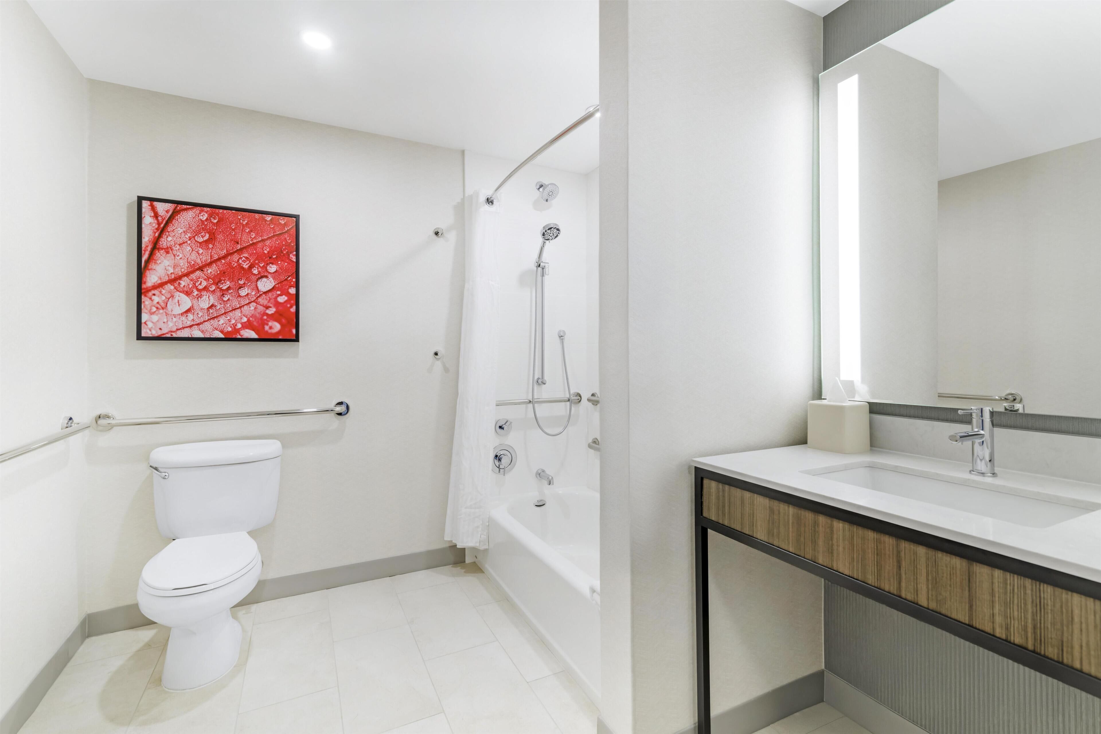 Un bagno moderno con un water, una doccia e un lavandino.