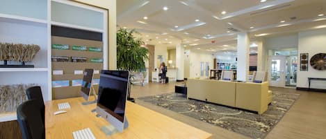 Un espacio de oficina moderno con escritorios, computadoras y una zona de recepción.