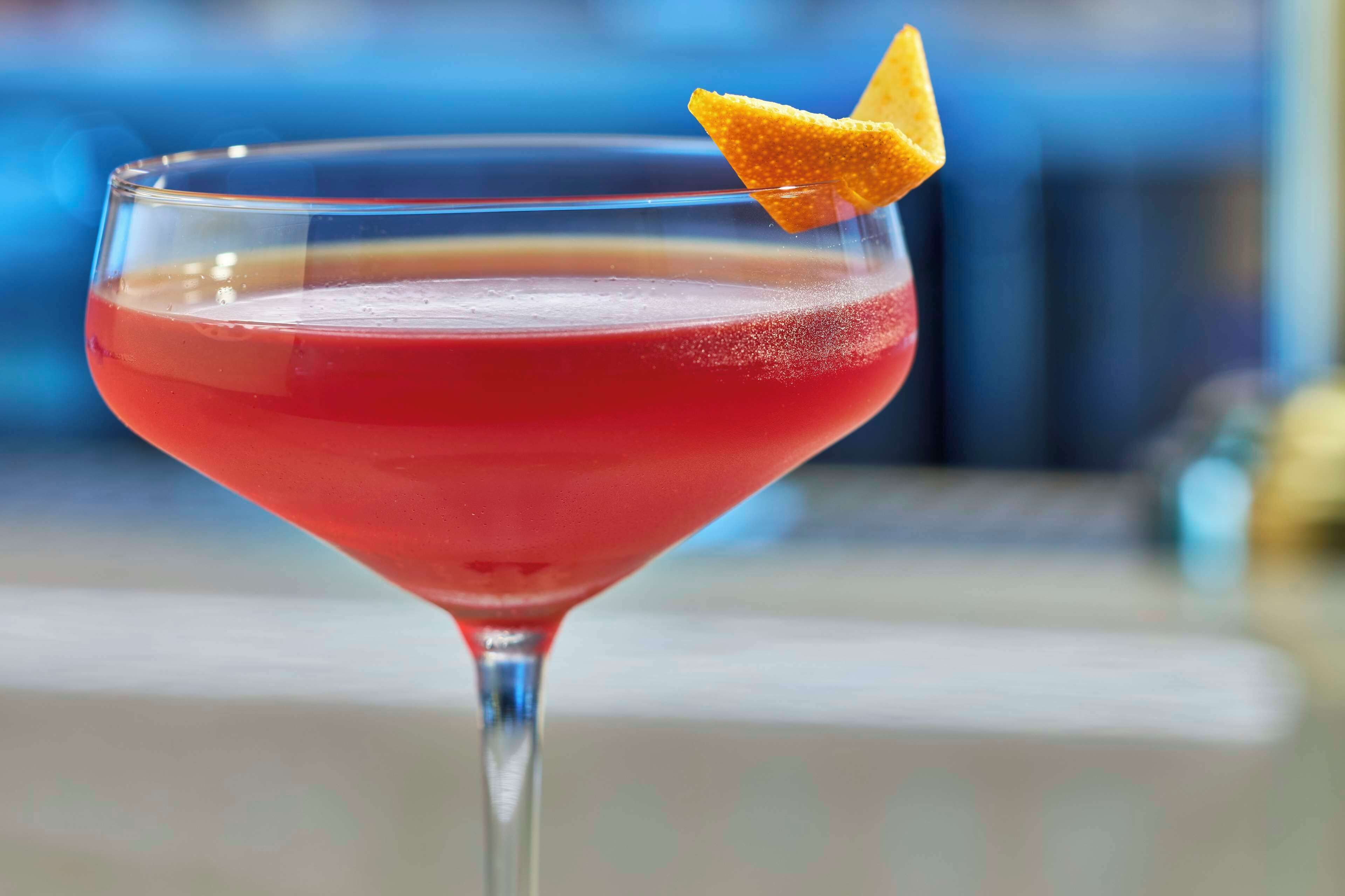 A cocktail in a martini glass with a lemon twist garnish.