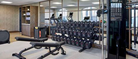 A gym with treadmills, dumbbells, and weight machines.