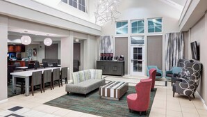 A spacious living area with a dining table, sofas, and a TV. - Residence Inn by Marriott Jackson Ridgeland (Ridgeland)