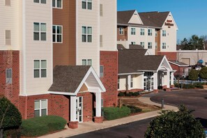 A multi-story residential building with a brick facade and white trim.