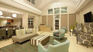 A spacious living area with a sofa, armchairs, and a coffee table. There is a dining area with chairs and a table, and a kitchen in the background. - Residence Inn by Marriott Jackson Ridgeland (Ridgeland)