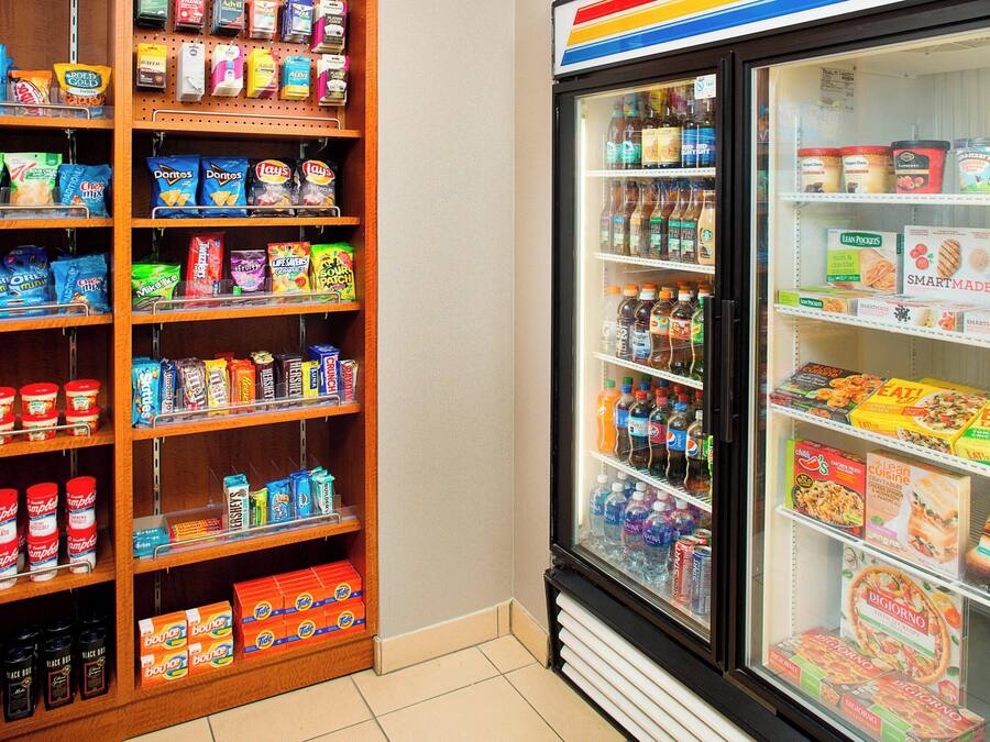 Ein Lebensmittelgeschäft mit Regalen voller Snacks, Getränke und Tiefkühlkost.