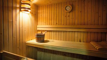 A wooden sauna with benches and a wooden bucket.