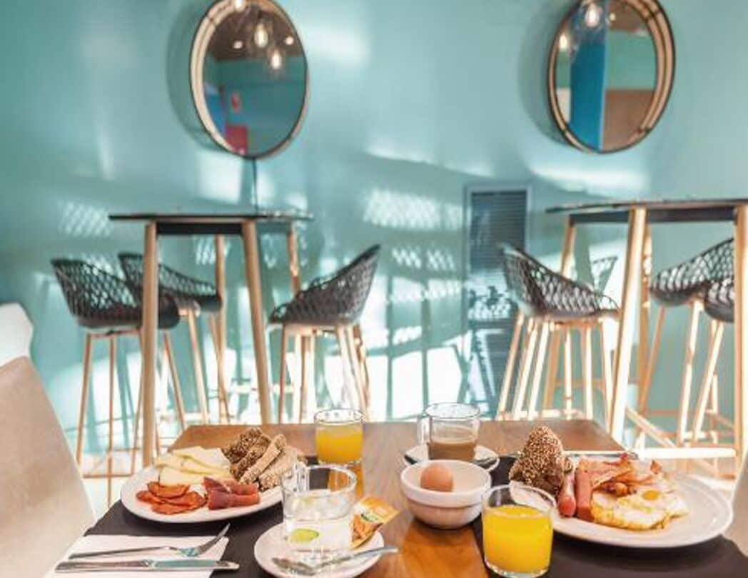 Un desayuno con platos de comida, bebidas y un cuenco de huevos.