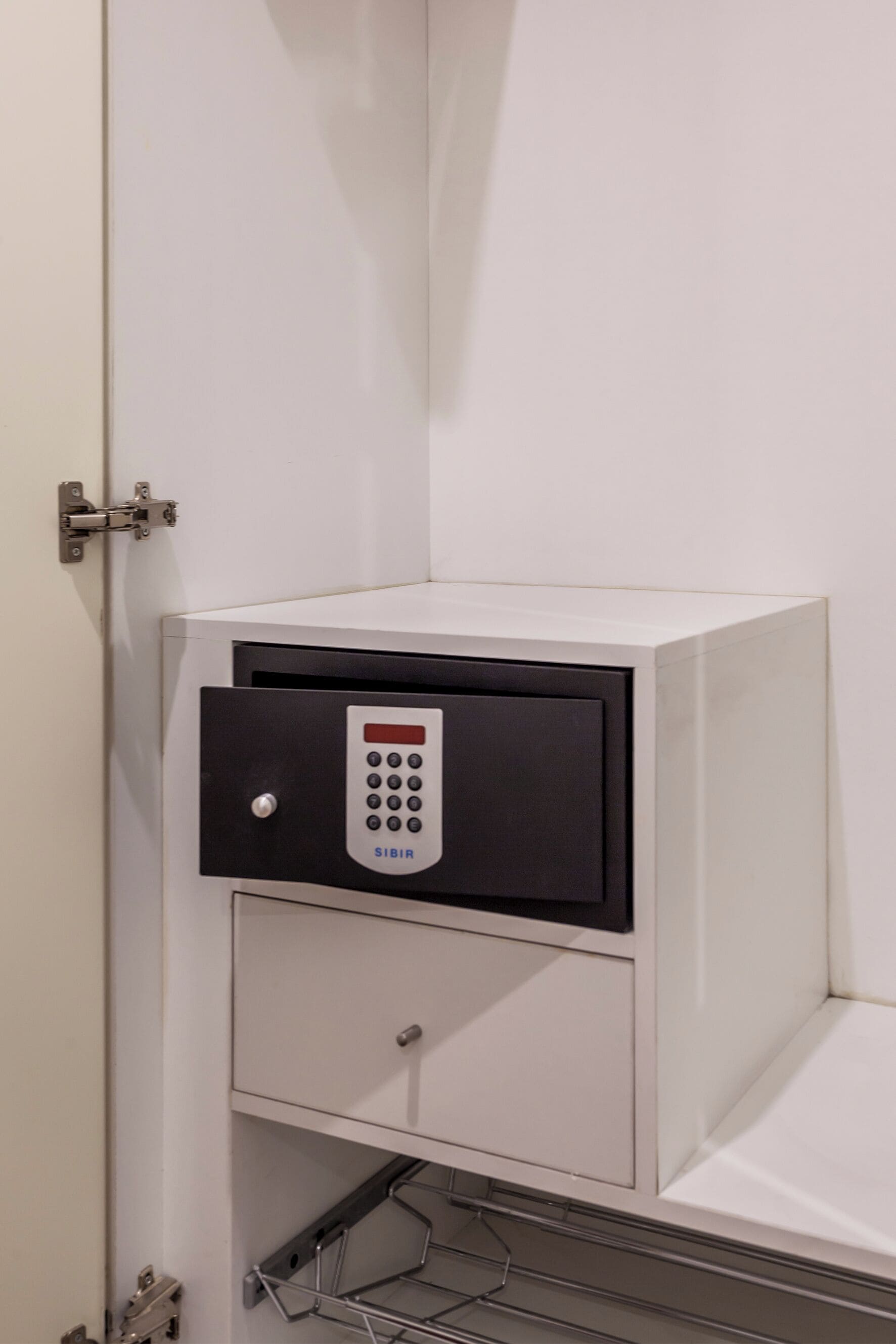 Un miniibar blanco con panel de control y un cajón pequeño.