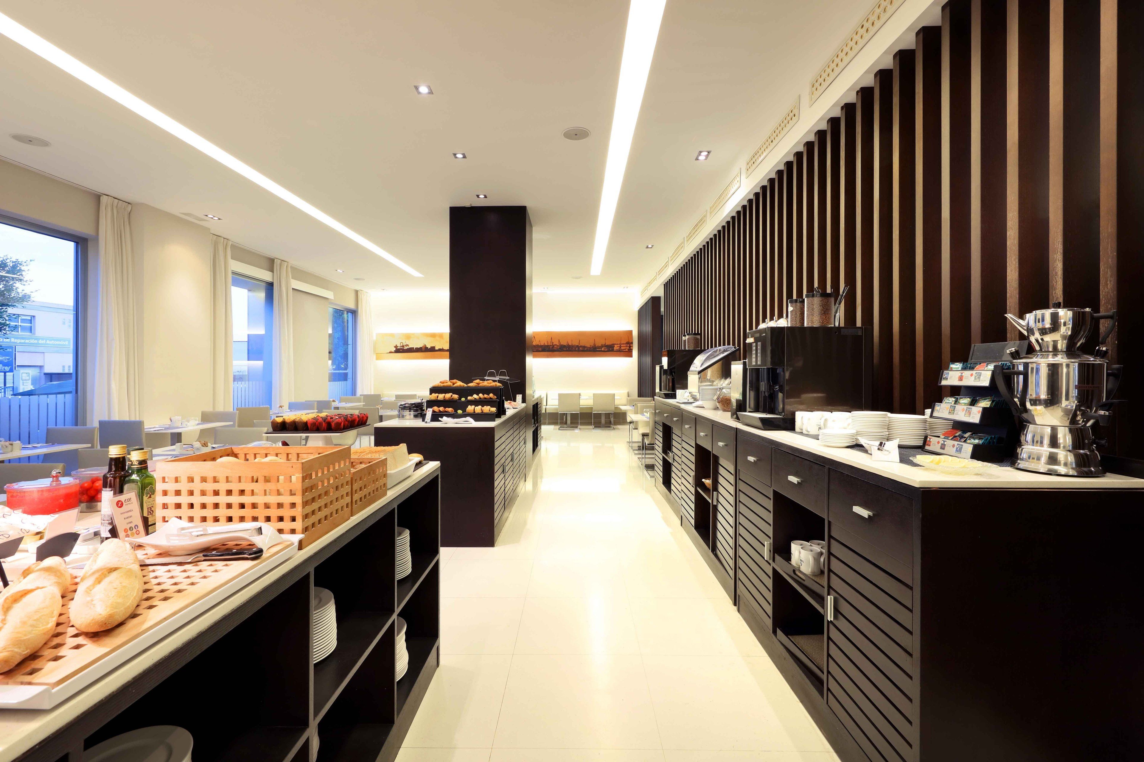 A modern kitchen with a central island, equipped with a coffee machine and various food items.