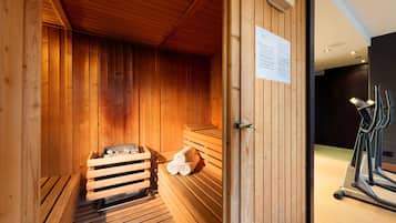Una sauna de madera con bancos y un banco con toallas.