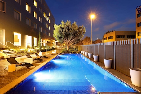 Una piscina al aire libre de temporada, sillones reclinables de piscina