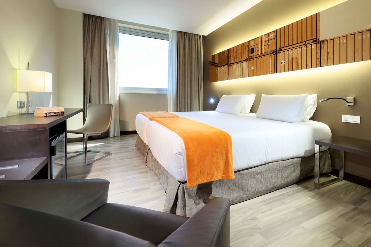 Ein Hotelzimmer mit einem Bett, einem Schreibtisch, einem Stuhl und einer Couch.