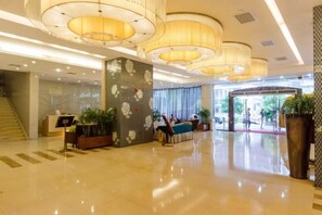 A spacious lobby with a reception desk, seating area, and a staircase. - Sichuan Hotel (Shenzhen)