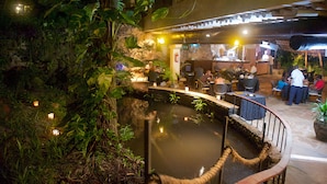 An indoor restaurant with a water feature, seating around the pool, and tropical plants. - Voyager Beach Resort (Mombasa)