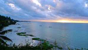 A coastal landscape with a beach, boats, and a sunset. - Voyager Beach Resort (Mombasa)