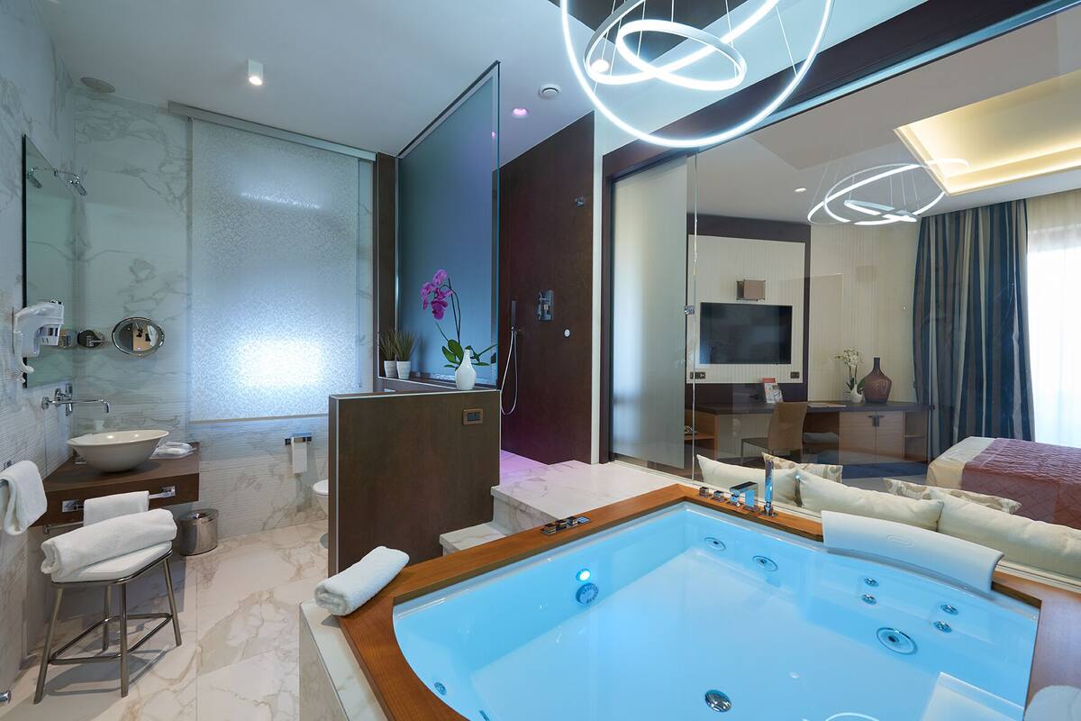 suite (jacuzzi) | bathroom | shower, rainfall showerhead, hair dryer, bathrobes