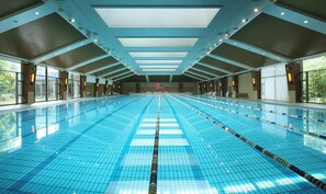 A large indoor swimming pool with multiple lanes, a high ceiling, and large windows. - Dongjiao State Guest Hotel (Shanghai)