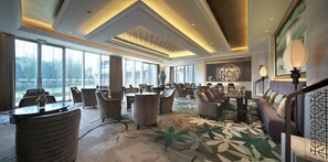 A hotel lobby with a large seating area, a reception desk, and a staircase. - Dongjiao State Guest Hotel (Shanghai)