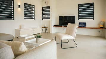 A modern living room with a sofa, coffee table, and a TV.
