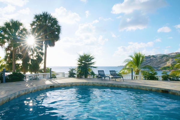 Een buitenzwembad, parasols voor strand/zwembad