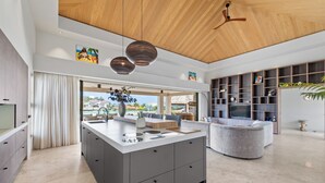 Une cuisine moderne dotée d’un îlot central, d’appareils électroménagers intégrés et d’une grande fenêtre donnant sur un paysage magnifique.