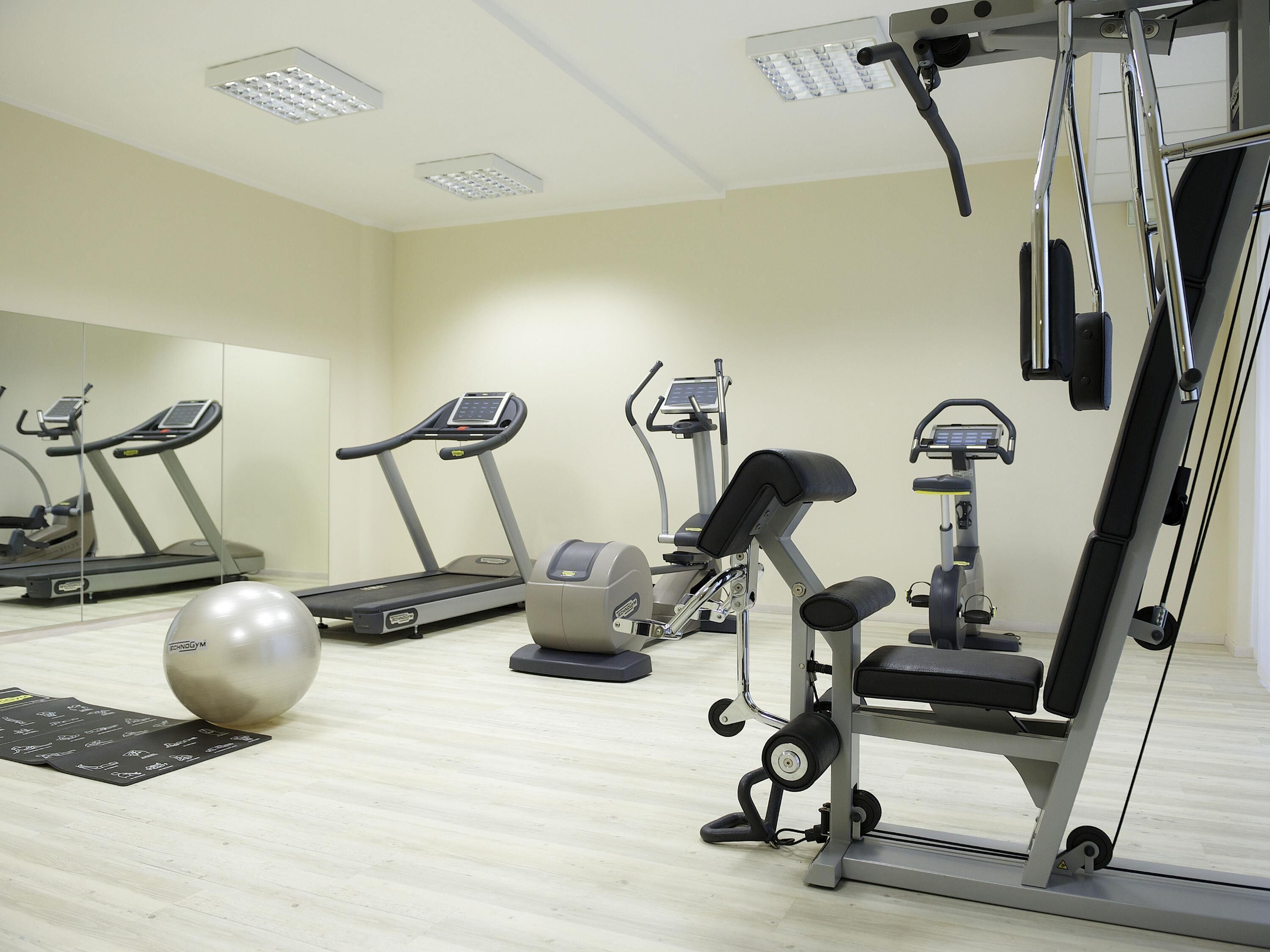 A gym with treadmills, elliptical machines, and a stationary bike.
