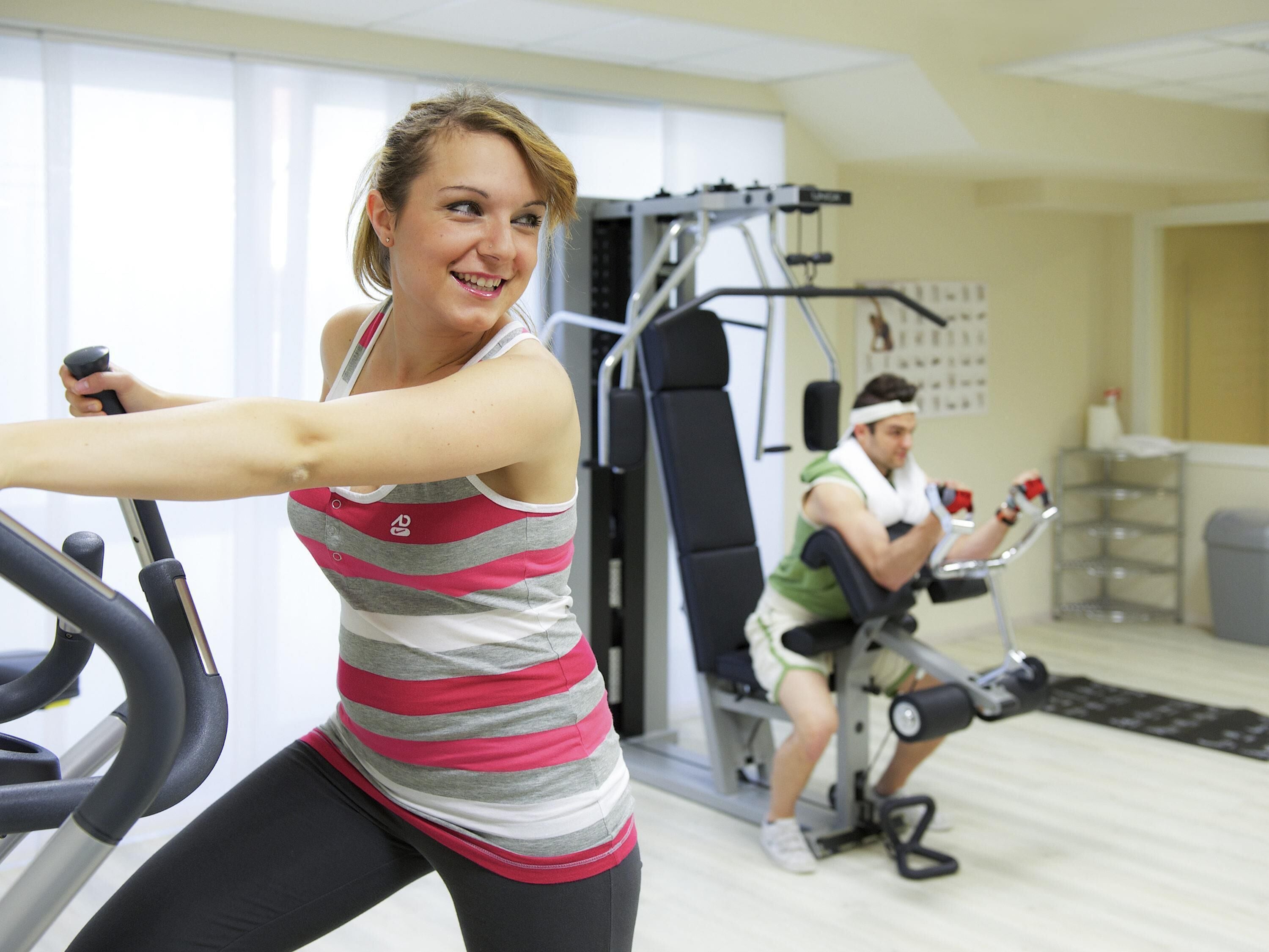 Un gimnasio con bicicletas estáticas y máquinas de pesas.