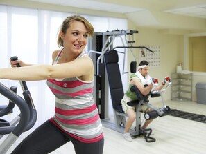 Une salle de sport équipée de vélos d’appartement et d’appareils de musculation.
