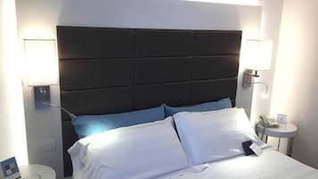A hotel room with a large bed, two bedside tables, and a modern headboard.