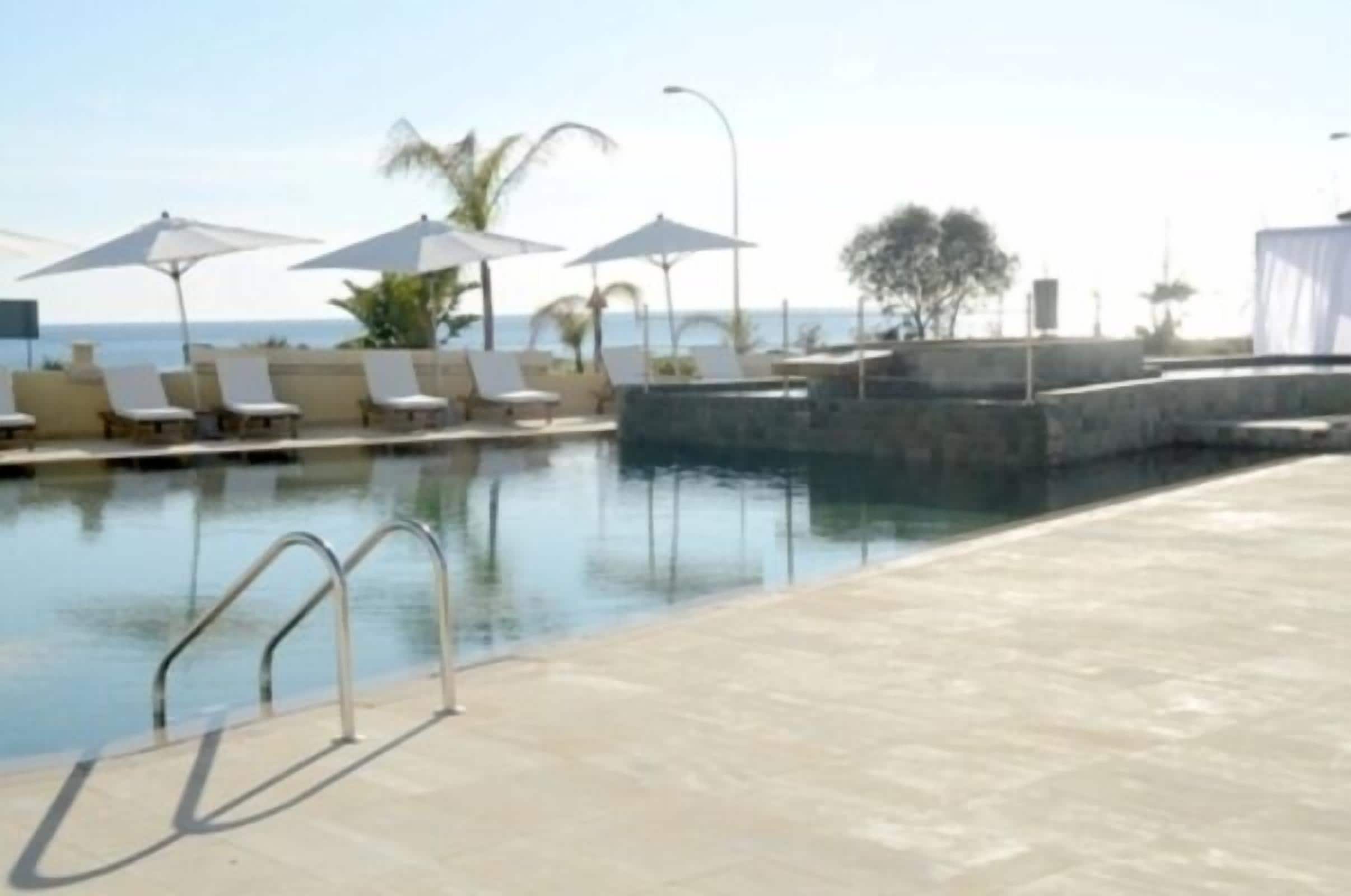 Alberca al aire libre, sombrillas en la alberca y camastros 