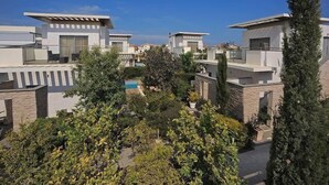A modern residential area with multiple houses, a swimming pool, and lush greenery. - E Hotel Spa & Resort Cyprus (Pervolia)