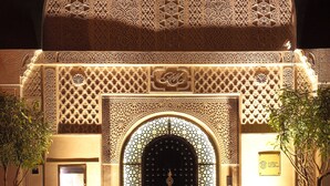 An ornate entrance with intricate geometric patterns and a dark, ornate door. - Le Riad Monceau (Marrakech)